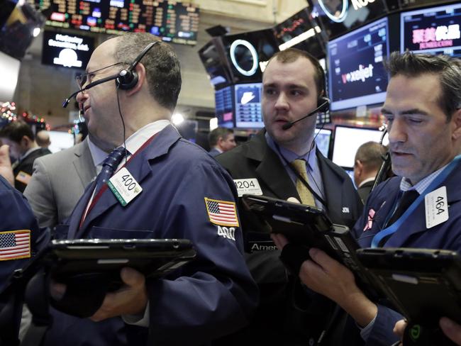 FILE - In this Dec. 16, 2015 file photo, traders Gordon Charlop, left, Nathan Wisniewski, center, and Gregory Rowe, work on the floor of the New York Stock Exchange. Stocks were mostly flat in early trading Tuesday, Dec. 22, 2015, helped by a stabilization in oil prices, which helped lift energy stocks. (AP Photo/Richard Drew, File)