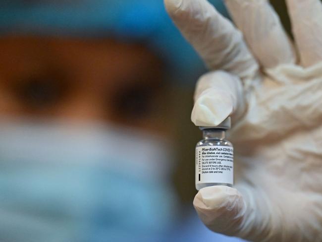 A health worker shows a vial of the Pfizer-BioNTech vaccine against COVID-19 at the Pascual Guerrero Olympic stadium, in Cali, Colombia, on April 26, 2021. (Photo by Luis ROBAYO / AFP)