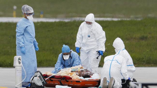 Medical staff prepare a patient infected with Covid-19 on a stretcher for an evacuation by helicopter to a hospital outside Paris. Picture: AFP