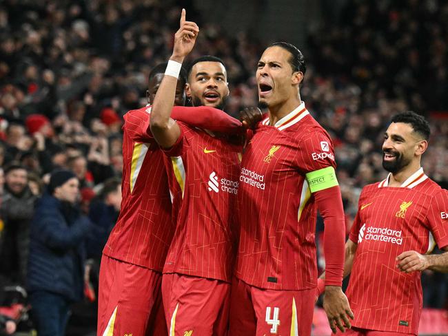 Liverpool's Dutch striker #18 Cody Gakpo (2L) celebrates scoring the team's second goal with Liverpool's Dutch defender #04 Virgil van Dijk during the UEFA Champions League football match between Liverpool and Real Madrid at Anfield in Liverpool, north west England on November 27, 2024. (Photo by Oli SCARFF / AFP)