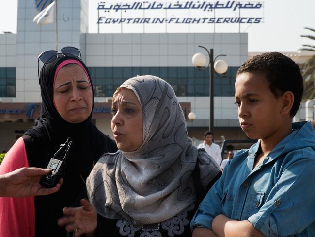 Family and friends talk with journalists in front of the EgyptAir in-flight services in Cairo.