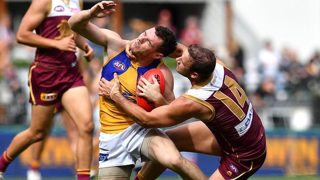 West Coast prime mover Luke Shuey gets a good old fashioned coathanger from Lion Josh Walker. Picture: Getty Images