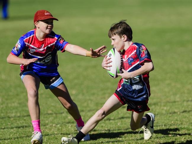 Jorden of Harristown State School Blue attempts to evade a touch from Libby Miller of Highfields State School in the inaugural Primary Interschools Reconciliation Touch Carnival hosted by Glenvale State School, Wednesday, May 28, 2025. Picture: Kevin Farmer