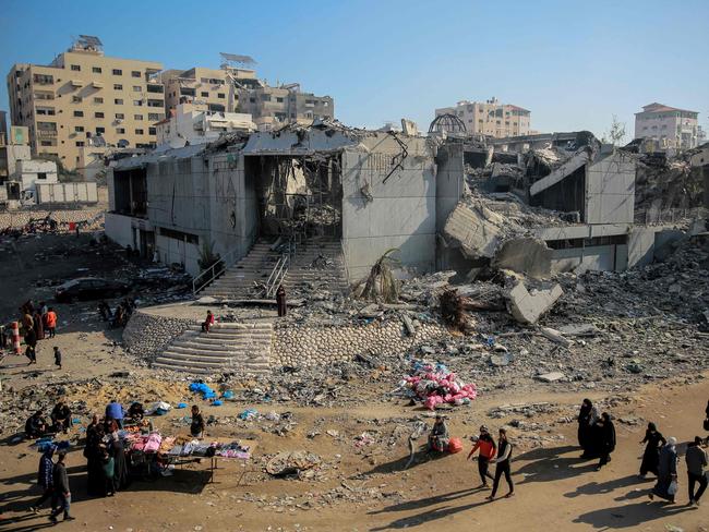People walk in front of the destroyed Rashad Shawa Cultural Centre during the ongoing battles between Israel and the Palestinian Hamas movement, in Gaza City. Picture: AFP