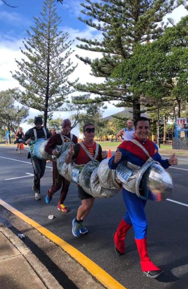 Ben Jansen, Jason Luke, Christopher Dale and Andrew Hauck break a world record at the Gold Coast Marathon for the fastest marathon run while dressed in a four-person suit. Photo: Contributed