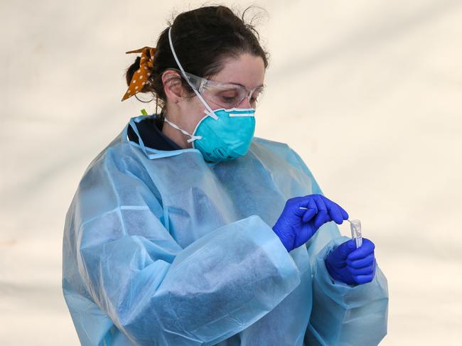 MELBOURNE, AUSTRALIA - JULY 04: A paramedic places a swab from a test into a test tube at a Covid-19 pop up testing centre in the hotspot suburb of Brunswick West on July 04, 2020 in Melbourne, Australia. Lockdowns across Melbourne are in effect for residents of suburbs identified as COVID-19 hotspots following a spike in new coronavirus cases through community transmission. Residents of the 10 Melbourne hotspot postcodes are only able to leave home have for exercise or work, to buy essential items including food or to access childcare and healthcare. Businesses and facilities in these lockdown areas are also restricted and cafes and restaurants can only open for takeaway and delivery. The restrictions will remain in place until at least 29 July.  (Photo by Asanka Ratnayake/Getty Images)