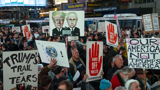 People attend a protest in Times Square New York the day after the resignation of Attorney General Jeff Sessions.