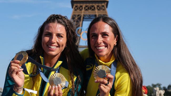 Australia's gold medallists and Jessica and Noemie Fox pose with their medals on stage at the Champions Park at Trocadero during the Paris 2024 Olympic Games in Paris on August 6, 2024, with the Eiffel Tower visible in the background. (Photo by Jack GUEZ / AFP)