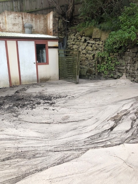 Sand blankets yards due to overflow from the golf course.