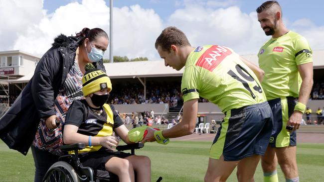 Umpire Alex Whetton hands Delean Brown a umpires jersey before the Hillcrest tribute game between Richmond and Hawthorn at Devonport. Picture: Grant Viney