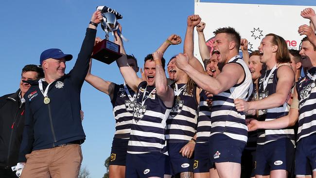 Macedon coach Jeff Andrews and captain James Wright hold aloft the premiership cup. Picture: George Salpigtidis