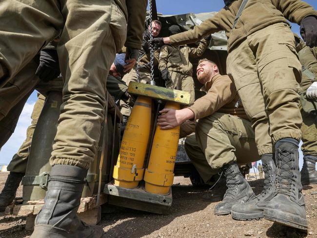 Israeli soldiers transport munitions off a vehicle at a position in the Israeli-annexed Golan Heights on January 2, 2023. - Israeli missile strikes on the Syrian capital's airport on January 2 killed four people including two soldiers and closed the runways for several hours, a rights monitor said. This is the second time in less than seven months that Damascus International Airport -- where Iranian-backed armed groups and Lebanese Hezbollah fighters are present -- has been hit by Israel. (Photo by JALAA MAREY / AFP)