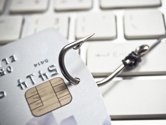 phishing - fish hook with a credit card on white computer keyboard credit card fraud generic, scammers, theft