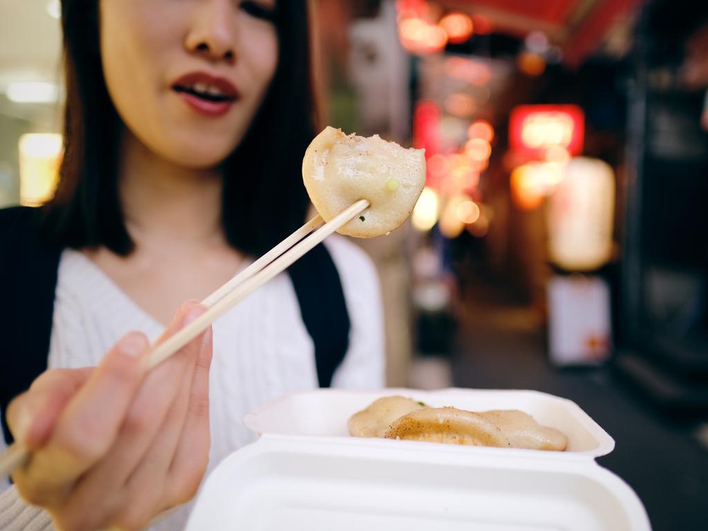 Woman eating take-out food on Izakaya street in Kichijoji, Tokyo, Japan Picture: istock