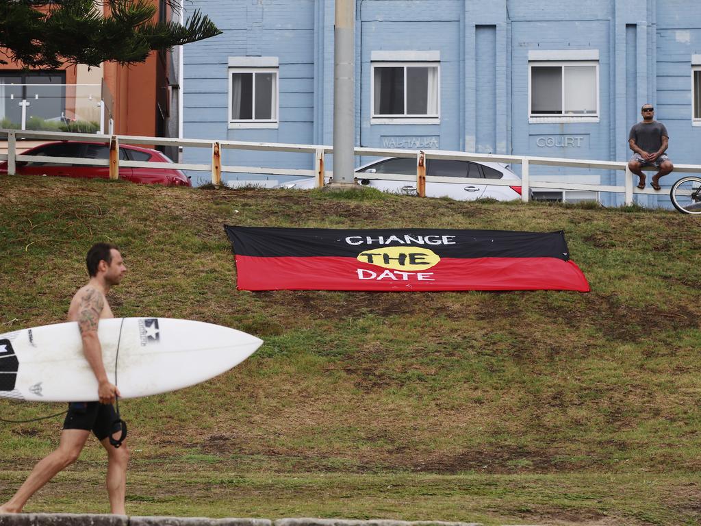 An aboriginal flag stating "Change The Date" is displayed at the southern end of Bondi Beach on Australia Day. Picture: Dylan Robinson