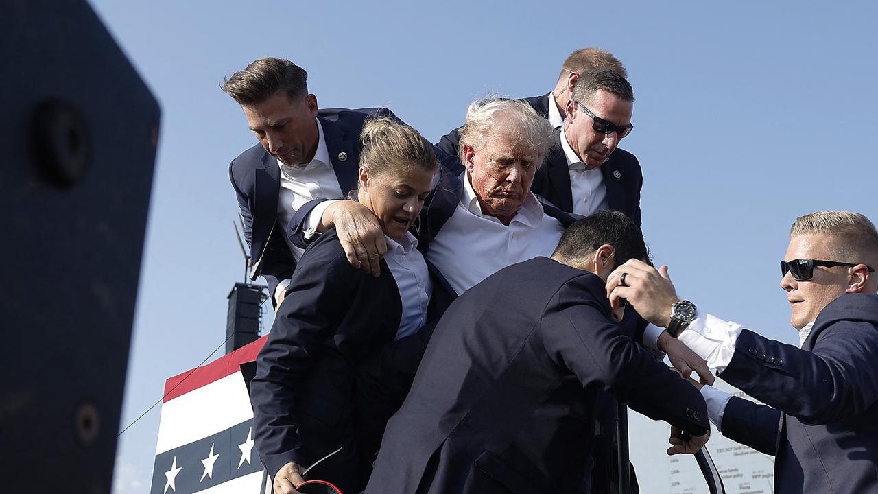 Trump slumped before being whisked away by Secret Service with injuries visible to the side of his head. Butler County district attorney Richard Goldinger said the shooter and one audience member are dead and another was injured. Picture: AFP