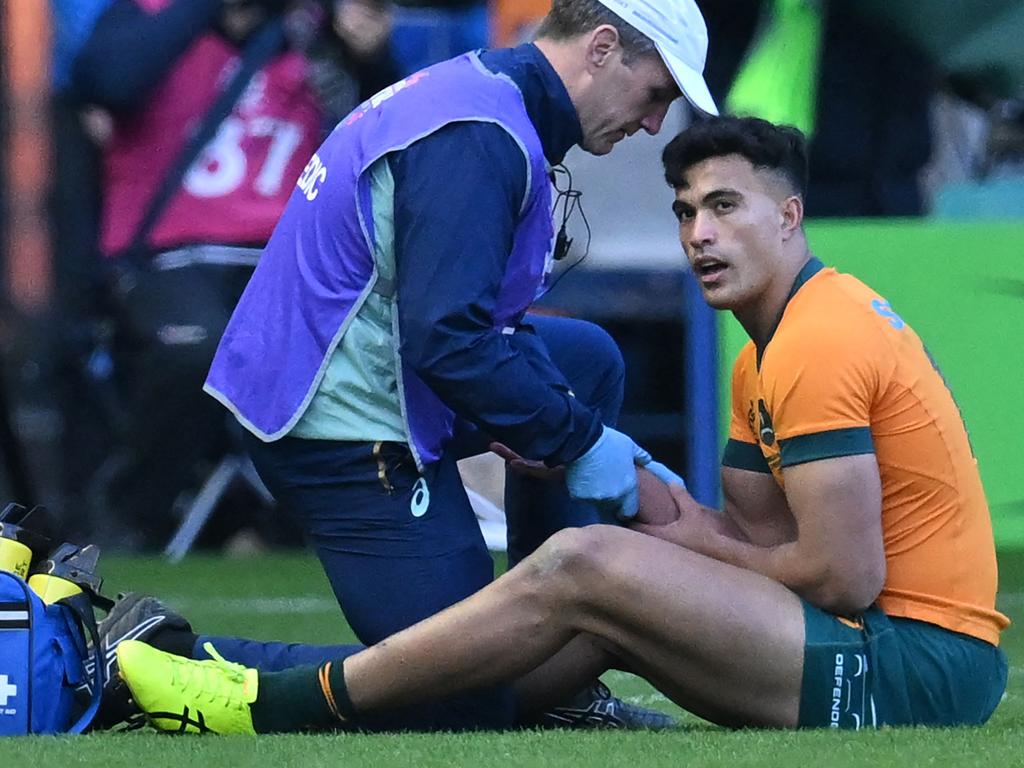 Wallabies centre Joseph-Aukuso Suaalii is treated by medical staff. Picture: AFP