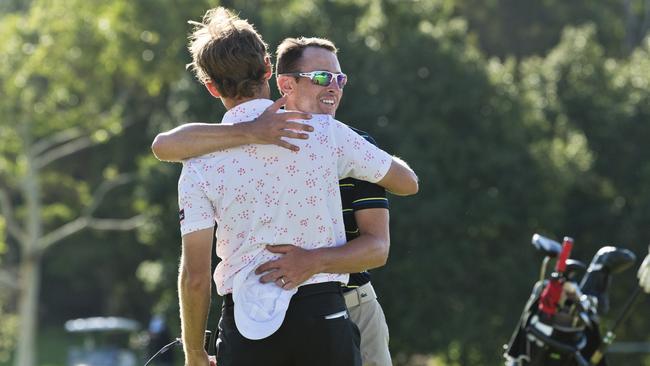 Scott Arnold (facing) congratulates close friend Michael Sim after a four-hole playoff.