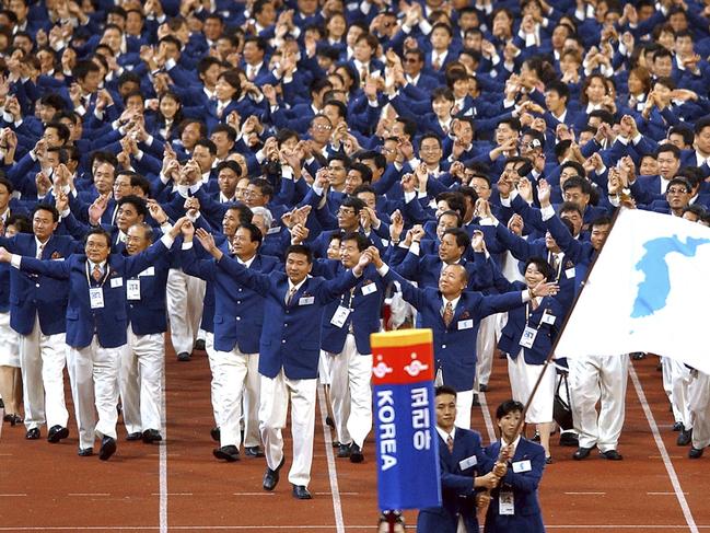 FILE - In this Sept. 29, 2002 file photo, athletes from North and South Korea march together, led by a unification flag, during an opening ceremony for the 14th Asian Games in Busan, South Korea. During South and North Korea's talks at the border in about a week Wednesday, Jan. 17, 2018, senior officials from the two Koreas reached a package of deals including fielding a joint women's hockey team and conducting a joint march under a 
