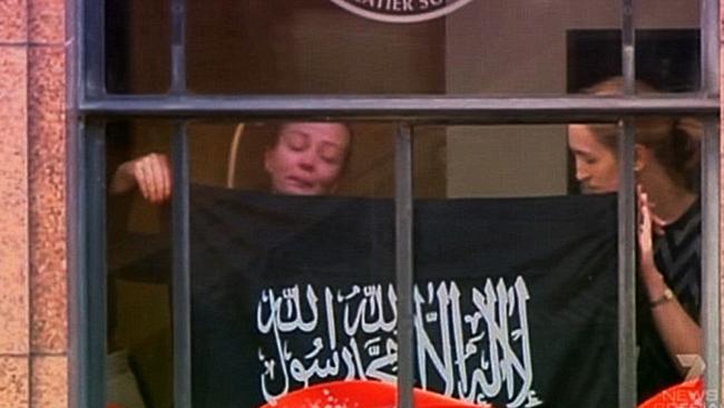 Earlier in the day police snipers watched as hostage Marcia Mikhael and others were forced to hold up a pro-Islamic State flag against the cafe window.