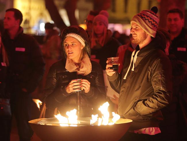 WINTER FEAST:A couple enjoy the winter feast from the comfort of a fire pit to keep them warm. Picture: LUKE BOWDEN