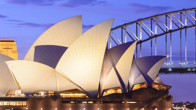 The Sydney Opera House illuminated at dusk.