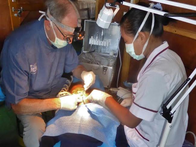 John Niven gets to work on a young boy’s teeth in Nepal.