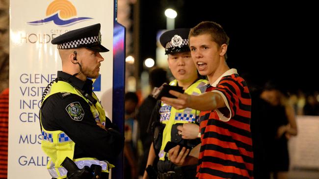 Glenelg traders are worried about police presence around Jetty Rd. Officers question a man in Mosley Square during 2016 New Year’s Eve celebrations.