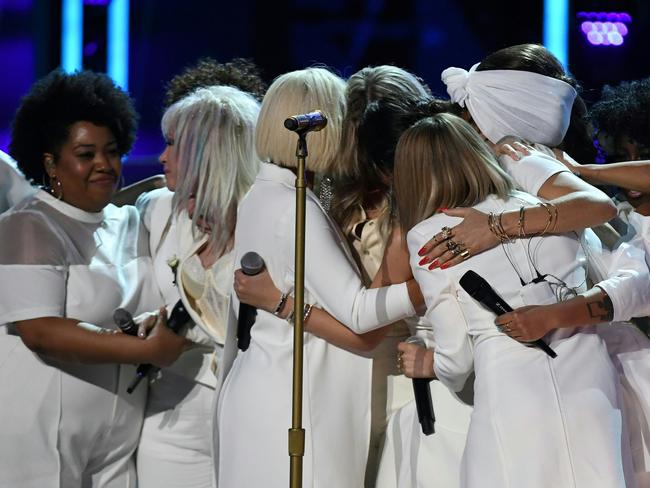 Kesha (unseen) is hugged by Bebe Rexha, Cindy Lauper, Camila Cabello and Andra Day during the 60th Annual Grammy Awards. Picture: AFP