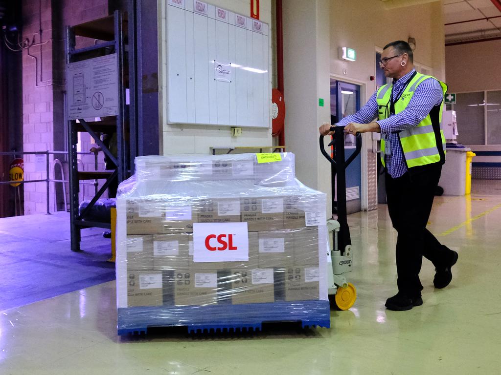 Workers at CSL roll the first batch of the AstraZeneca vaccine into waiting trucks on March 24. Picture: Luis Ascui/Getty Images