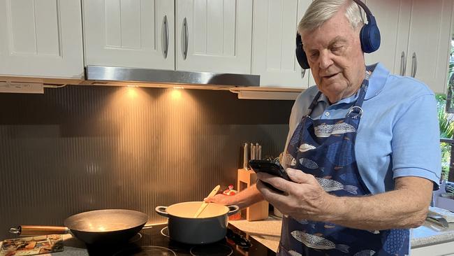 Cancer survivor Terry Ryder tunes in to the choir while cooking his favourite meal. Picture: Contributed