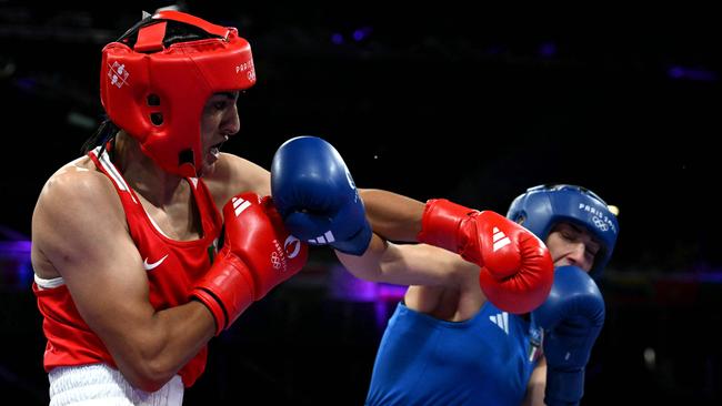 Khelif hits Carini with a left hook. (Photo by MOHD RASFAN / AFP)