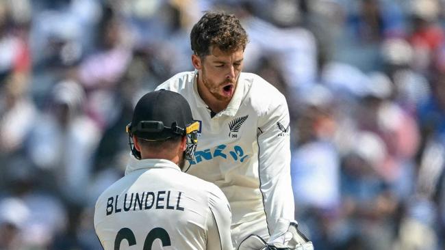 TOPSHOT - New Zealand's Mitchell Santner celebrates with his teammate Tom Blundell (L) after taking the wicket of India's captain Rohit Sharma during the third day of the second Test cricket match between India and New Zealand at the Maharashtra Cricket Association Stadium in Pune on October 26, 2024. (Photo by Punit PARANJPE / AFP) / -- IMAGE RESTRICTED TO EDITORIAL USE - STRICTLY NO COMMERCIAL USE --