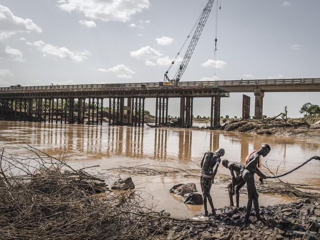 South Ethiopia. Kangata. 2017 .Men of the Nyangatom ethnic group work by the shore of the Omo River. Behind them, there’s the construction of a bridge that will merge the territory of the Karo with the territory of the Nyangatom. Picture: Fausto Podavini/World Press Photo