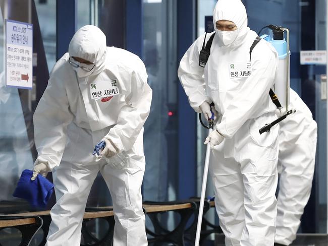 South Korean soldiers wearing protective gears disinfect as a precaution against the new coronavirus at a train station in Daejeon, South Korea, Thursday, June 25, 2020. (Kim Jun-beom/Yonhap via AP)