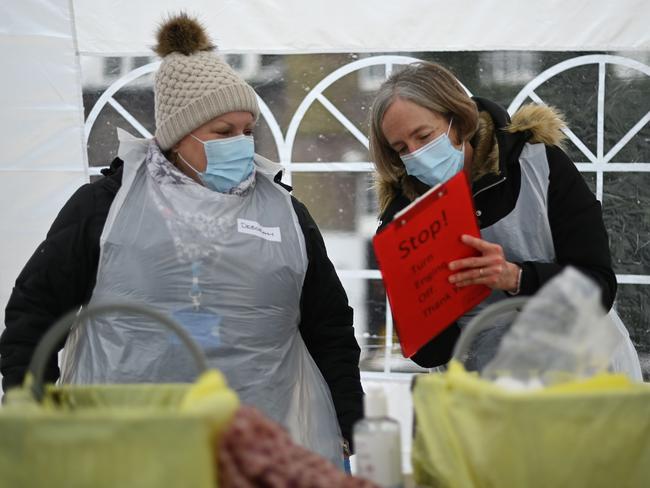 Health workers prepare COVID-19 vaccine injections at a drive through vaccination centre in London. Picture: AFP