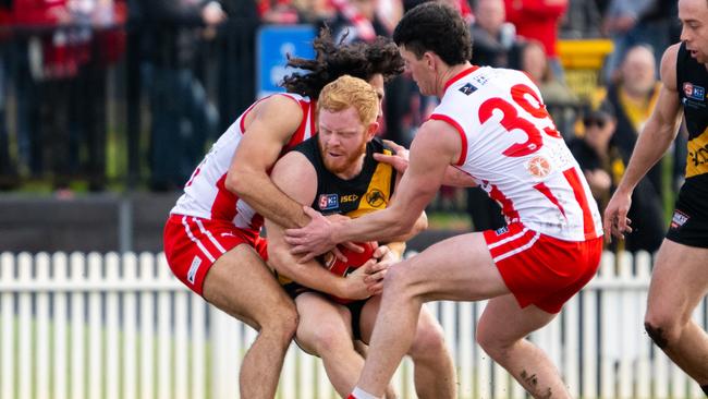 Glenelg’s Darcy Bailey is wrapped up by the Roosters. Picture: Morgan Sette