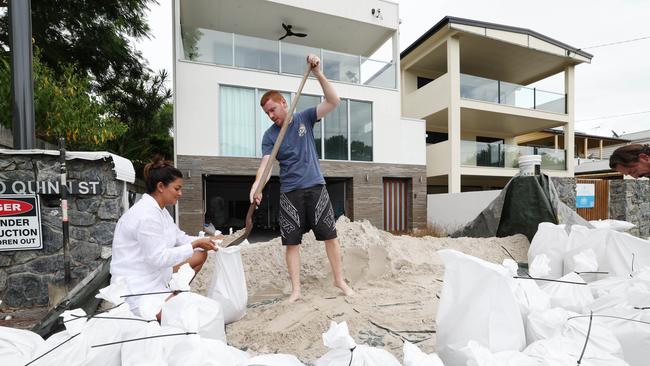 Artika Lunow sandbags her home at Nudgee Beach. Picture: Annette Dew