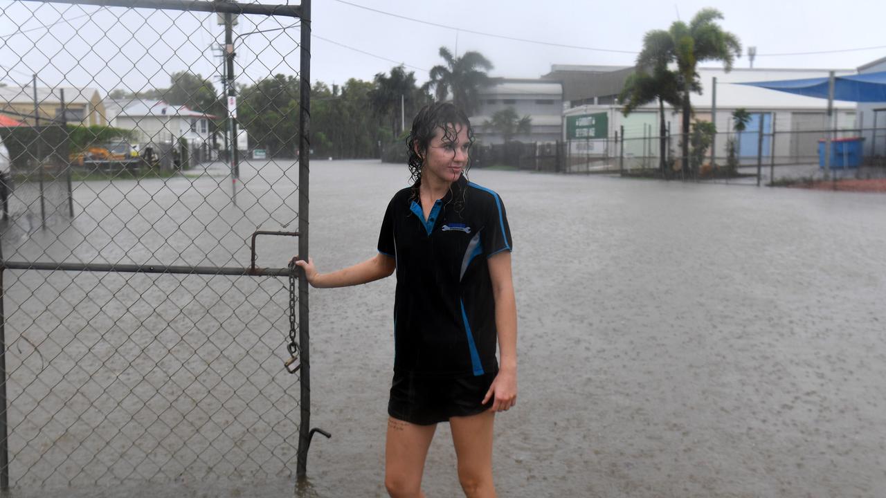 Saturday February 1. Heavy rain lashes Townsville causing flash flooding. Erin Hollaway locks up a gate in Camgulia Street, Mt Louisa. Picture: Evan Morgan