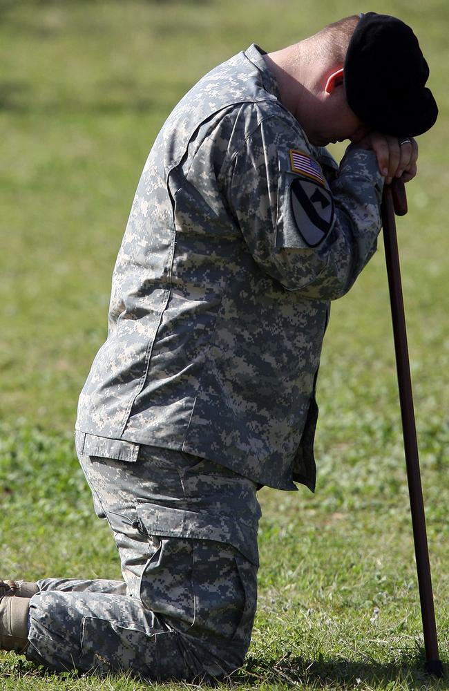 US Army Specialist Brian Hill kneels during a service for Fort Hood victims in 2009.