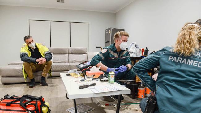 Mr Malinauskas watches paramedics Luke Nottage and Jess Bastian work with a patient. Picture: Brenton Edwards