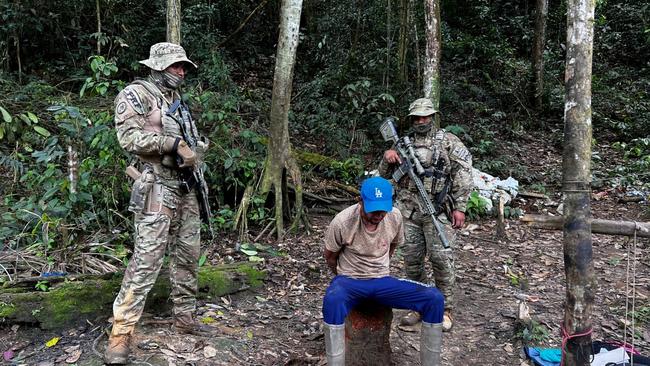 Officers from Brazil’s environmental protection agency arrest an illegal miner during an operation against deforestation in February. Picture: Getty Images