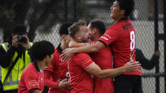 Ndue Mujeci is mobbed by North Sunshine teammates. Picture: Andrew Batsch