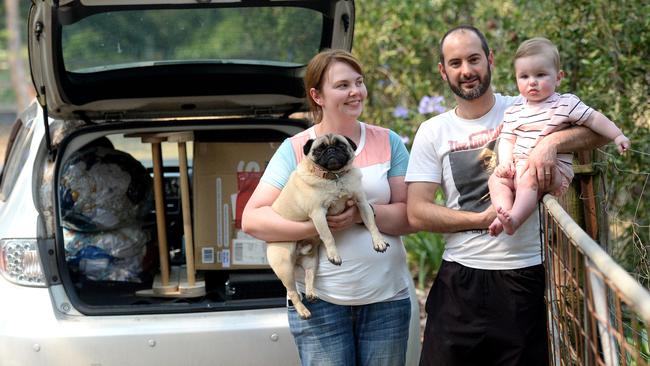 Residents Michael and Ashleigh Kalonikos with their eight-month-old son Theodore and dog Bert plan to leave the area as bushfire threatens their home. Picture: Jeremy Piper