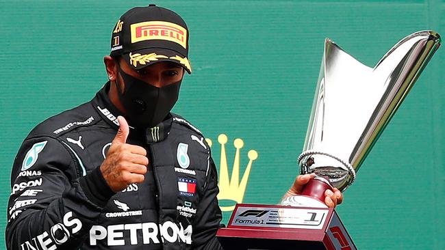 Mercedes' British driver Lewis Hamilton gestures on the podium