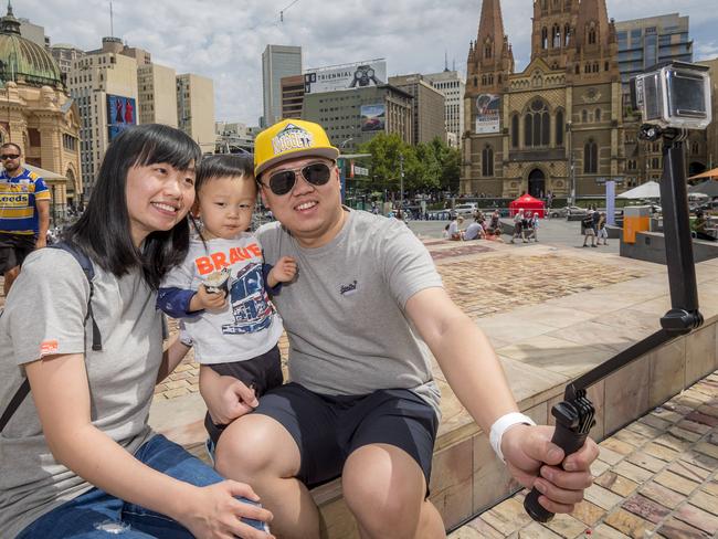 Li, son Evan and husband Wang Wenxiao from China in Federation Square. Picture: Jason Edwards