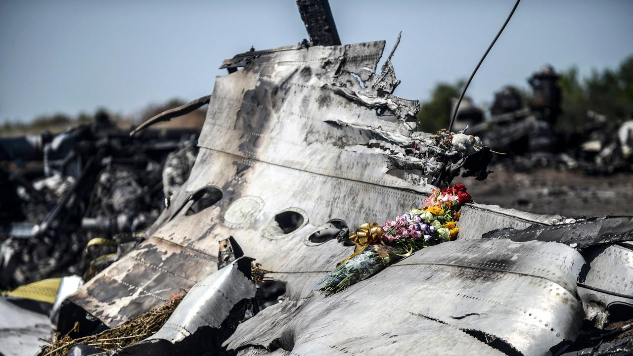 Flowers are seen left by parents of an Australian victim of the crash on a piece of the wreckage near Hrabove on July 26, 2014. Picture: Bulent Kilic / AFP