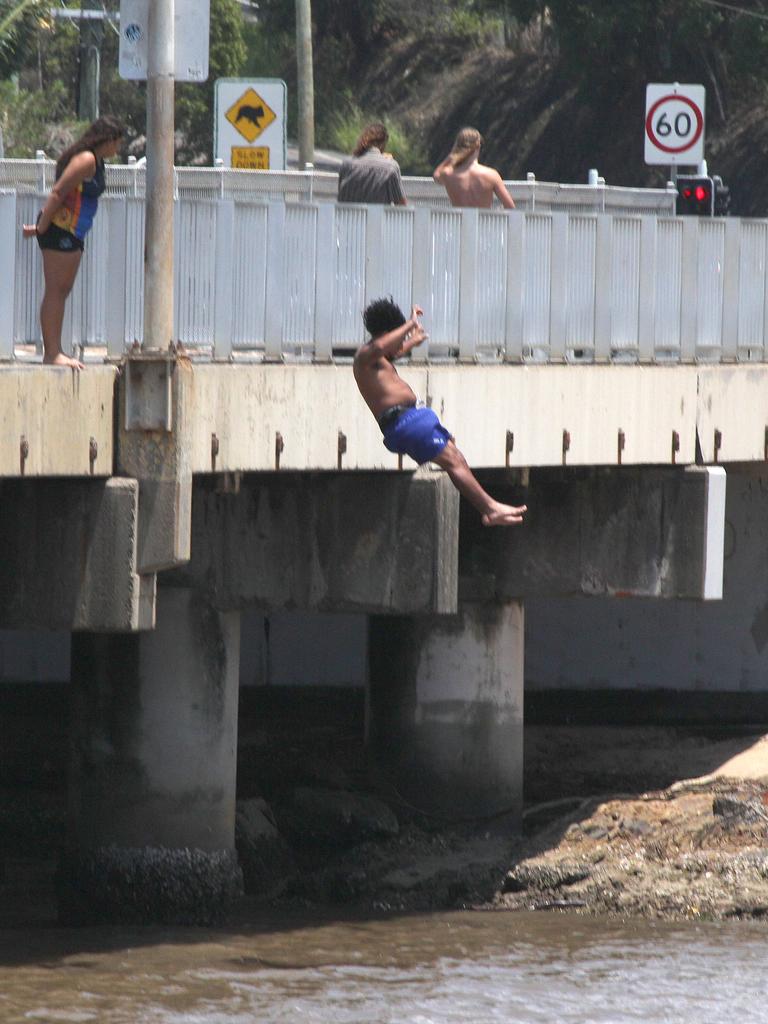 Young Teens risk serious injury by bridge Jumping at the Tallebudgera crkn Bridge as Tree debree passes in the Muddy water.Pic Mike Batterham