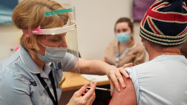 A priority worker receives the Pfizer BioNTech COVID-19 vaccine at a mass UK vaccination hub. Australia’s chief health officer has said the vaccine rollout will not mean the end of restrictions here. Picture: Ian Forsyth/Getty Images