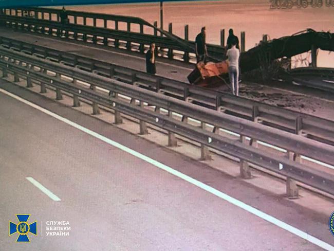 People inspecting damage to the Kerch Bridge connecting Crimea with Russia following the blast. Picture: AFP